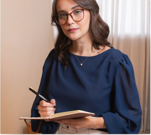Retrato corporativo da psicóloga Fernanda Ananias escrevendo em caderno