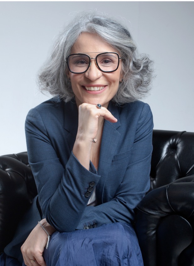 Retrato corporativo de consultora sênior sorrindo em poltrona